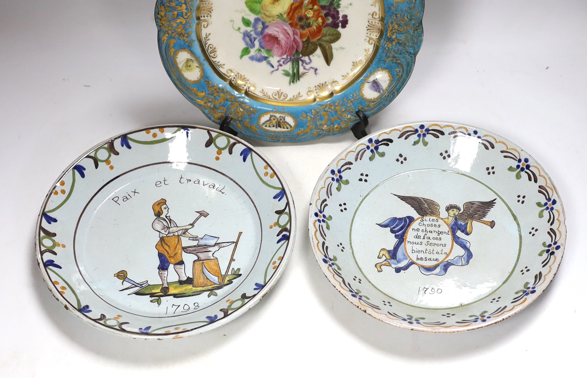 A pair of French revolution commemorative faience dishes and an 18th century Sevres plate, with later decoration, largest 23cm in diameter